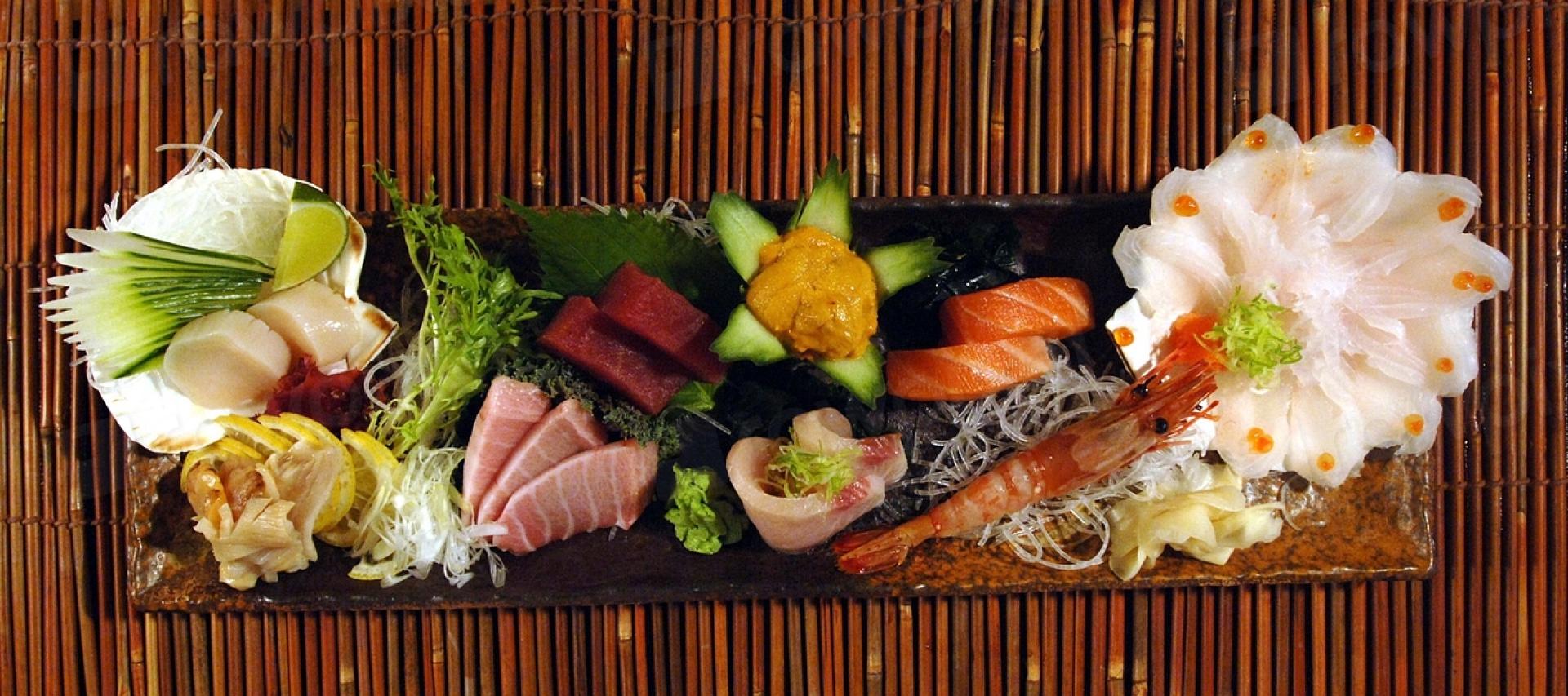 Omakase sashimi dinner spread on a dark stone platter